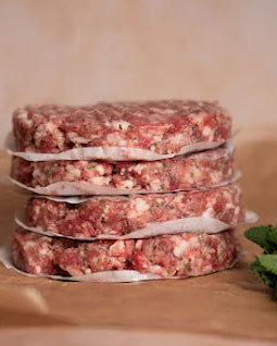 Stack of pork and apple burgers on a brown background